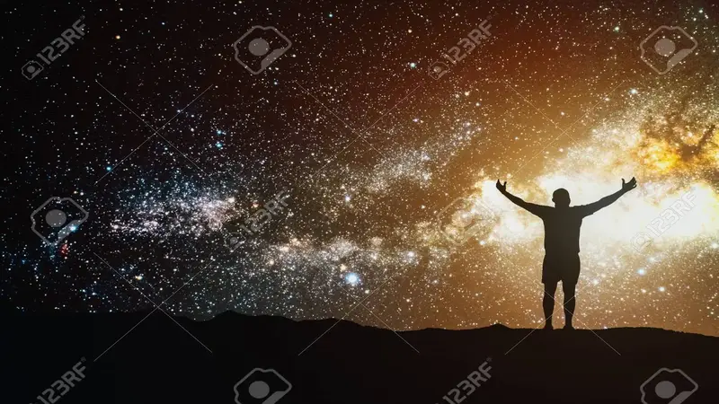 Silhouette d’une personne bras levés face à un ciel nocturne rempli d’étoiles et de la Voie lactée